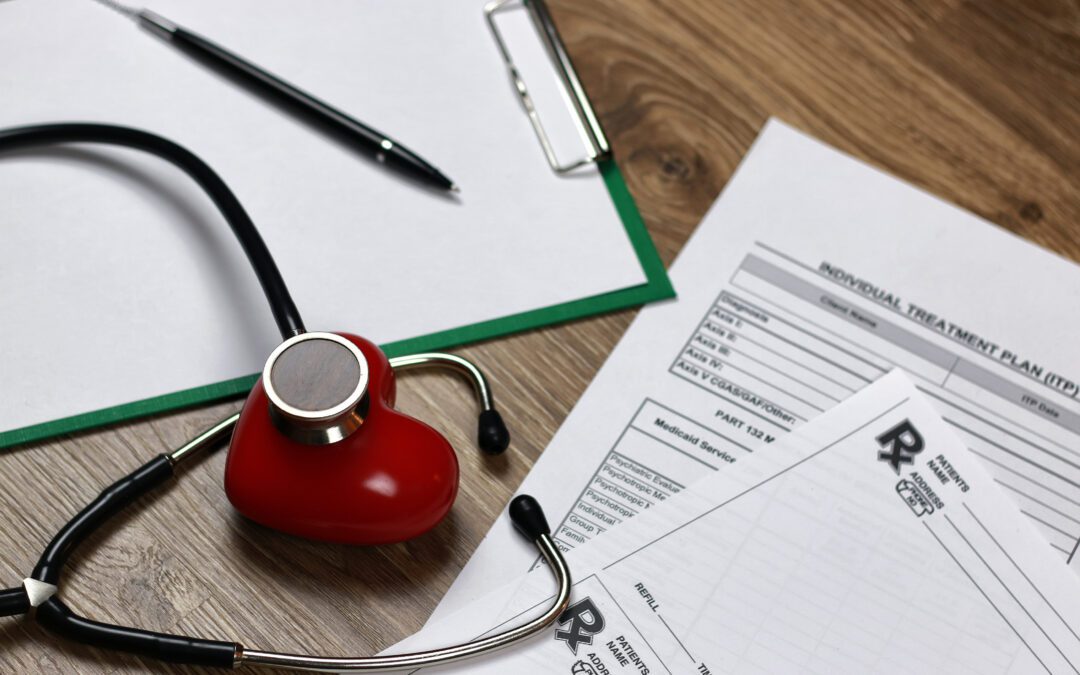 A pad with blank paper, a heart-shaped stethoscope, and an unsigned Medicare formulary drug list are placed on a table