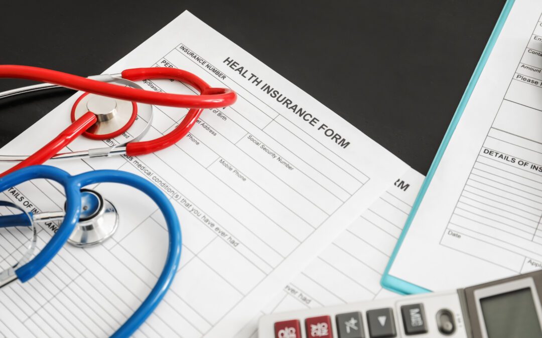 Stethoscope placed on a form with "Health Insurance" written on it, symbolizing healthcare coverage.