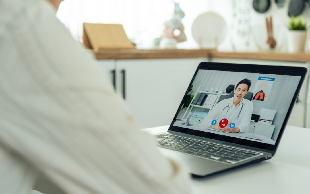 A man speaks to his doctor on his laptop during an online consultation.